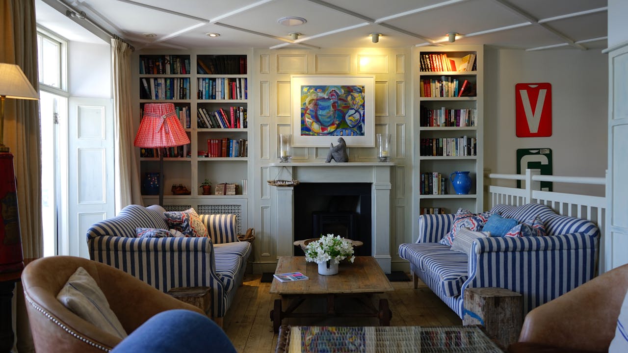 why-choose-us Stylish living room with modern decor, striped couches, and a cozy fireplace.