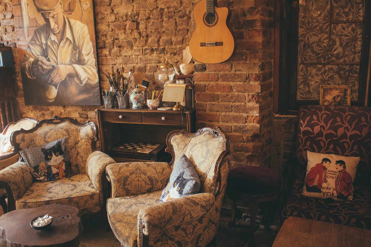 creative-03 Warm vintage room with armchairs, guitar, and artwork on a brick wall, creating a cozy atmosphere.